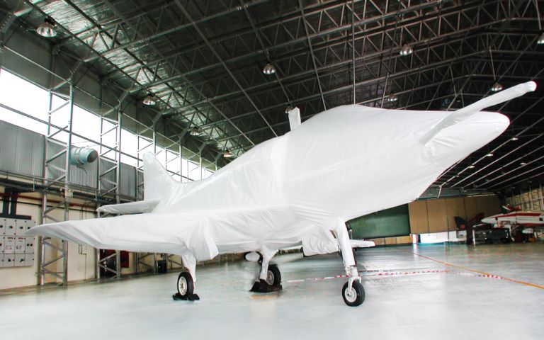 Aircraft wrapped in protective coated fabric inside a hangar